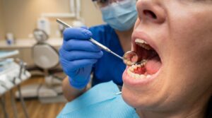 Dentist examining a patient's gums for signs of bleeding and swelling